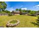 Large backyard with lush green grass, mature trees, fenced perimeter, and stone flower bed detail at 255 Mcintosh Estates Dr, Sharpsburg, GA 30277