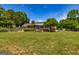 Large backyard with lush green grass, mature trees, patio with pergola, and a partial fence line at 255 Mcintosh Estates Dr, Sharpsburg, GA 30277