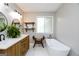 Elegant bathroom boasts a dual sink vanity, stylish fixtures, a soaking tub, and open shelving at 255 Mcintosh Estates Dr, Sharpsburg, GA 30277
