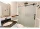 Updated bathroom features granite counters, decorative shelf, and a stylish, frameless sliding glass shower door at 255 Mcintosh Estates Dr, Sharpsburg, GA 30277