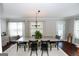 Charming dining room with large windows, chandelier, hardwood floors and neutral paint at 255 Mcintosh Estates Dr, Sharpsburg, GA 30277