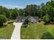 Charming home featuring a long, bright driveway and a beautifully landscaped front yard at 255 Mcintosh Estates Dr, Sharpsburg, GA 30277