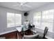 Bright home office features a glass desk, wood floors, and natural light streaming through two large windows at 255 Mcintosh Estates Dr, Sharpsburg, GA 30277