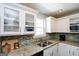 Modern kitchen features granite countertops, stainless appliances, and white cabinets at 255 Mcintosh Estates Dr, Sharpsburg, GA 30277