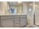 Bright bathroom featuring double vanity, large mirror, and walk-in shower with glass door at 1005 Belfry Ter, Fairburn, GA 30213