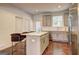 Well-lit kitchen with granite countertops, stainless appliances, an island with counter seating, and hardwood floors at 1005 Belfry Ter, Fairburn, GA 30213