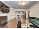 Open-concept layout with a stylish electric fireplace, dark hardwood flooring, and view into the kitchen at 1005 Belfry Ter, Fairburn, GA 30213