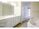Bathroom featuring dual sinks, a large mirror, and a soaking tub at 335 Grand Teton Cir, Fayetteville, GA 30215