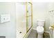 Bright bathroom featuring tiled floors, a toilet, and a shower with a gold frame at 335 Grand Teton Cir, Fayetteville, GA 30215