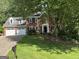 Traditional brick home with a three-car garage and well-manicured lawn in a lush setting at 3146 Weymouth Dr, Marietta, GA 30062
