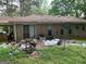 Backyard with brick home, overgrown grass and debris at 4116 Warrior Trl, Stone Mountain, GA 30083