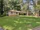 Single story brick home with shutters surrounded by lush landscaping at 4116 Warrior Trl, Stone Mountain, GA 30083