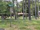 A house surrounded by tall trees on a green lawn and a 'Hawkeye' street sign at 4116 Warrior Trl, Stone Mountain, GA 30083