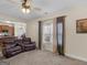 Cozy living room featuring a fireplace, ceiling fan, and comfortable leather seating at 138 Brookhaven Dr, Villa Rica, GA 30180