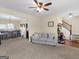 Spacious living room with sofa, adjacent bar area, and hardwood stairs at 138 Brookhaven Dr, Villa Rica, GA 30180