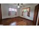Cozy bedroom featuring wood floors, a ceiling fan, and natural light from the two windows at 305 Flat Shoals Church Rd, Stockbridge, GA 30281