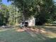 Large backyard with a play set, fire pit, and mature trees, offering a peaceful outdoor space at 126 Country Acres Ct, Mcdonough, GA 30253