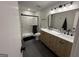 Updated bathroom featuring double sinks, wood cabinets, tile floors, and glass enclosed shower at 126 Country Acres Ct, Mcdonough, GA 30253