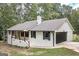Charming white brick home with a covered porch and attached garage, surrounded by mature trees at 126 Country Acres Ct, Mcdonough, GA 30253