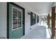 Covered porch with green entry door, black trim, and updated lighting fixtures at 126 Country Acres Ct, Mcdonough, GA 30253