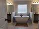 This bathroom features a soaking tub with double sink vanities on either side and tile floors at 436 Lothbury Ave, Locust Grove, GA 30248