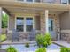Inviting front porch with rocking chairs, brick accents, and manicured landscaping, perfect for relaxing outdoors at 436 Lothbury Ave, Locust Grove, GA 30248