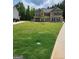 Expansive front lawn featuring a young tree and a basketball hoop, offering ample space for outdoor activities at 436 Lothbury Ave, Locust Grove, GA 30248
