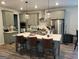 Eat-in kitchen features a large island with seating, stainless steel appliances, and modern pendant lighting at 436 Lothbury Ave, Locust Grove, GA 30248