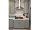 Modern kitchen featuring sleek countertops, subway tile backsplash, stainless steel range hood, and gray cabinetry at 436 Lothbury Ave, Locust Grove, GA 30248