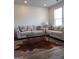 Bright living room featuring two couches, wood floors, a large window, and a unique cowhide rug at 436 Lothbury Ave, Locust Grove, GA 30248