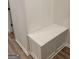 White mudroom built-in bench with storage, located off the hallway with wood flooring at 436 Lothbury Ave, Locust Grove, GA 30248