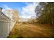 View of the expansive backyard with a white picket fence and tall trees at 577 Rivers Rd, Fayetteville, GA 30214