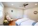This bedroom offers a cozy reading chair, wood flooring, and a ceiling fan at 577 Rivers Rd, Fayetteville, GA 30214