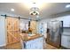 Updated kitchen features stainless appliances, an island, and barn doors to the living room at 577 Rivers Rd, Fayetteville, GA 30214