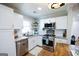 Bright kitchen with stainless steel appliances, granite counters, and white cabinetry at 577 Rivers Rd, Fayetteville, GA 30214