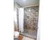 The gorgeous walk-in shower features marble-style tiling, black mosaic flooring, and a built-in niche at 577 Rivers Rd, Fayetteville, GA 30214