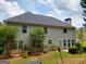 Two-story home with many windows, a grey roof, a chimney and landscaped yard with mature trees at 75 Trelawney Keep, Covington, GA 30016