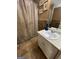 Neutral toned bathroom showcasing a vanity with white cabinets, framed artwork, and a decorative shower curtain at 75 Trelawney Keep, Covington, GA 30016