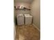 This cozy laundry room includes tile flooring, shelving, and washer and dryer units at 75 Trelawney Keep, Covington, GA 30016