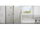 A modern bathroom featuring a glass-enclosed shower, soaking tub, and window for natural light at 1246 Trombone Way # 111, Mcdonough, GA 30252