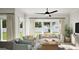 Bright living room with modern furnishings, large windows overlooking the yard, and a stylish ceiling fan at 2024 Piccolo Ct # 228, Mcdonough, GA 30252