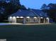 Well-lit home at dusk featuring an attached garage and well-maintained lawn at 376 Turner Cir, Mcdonough, GA 30252
