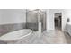 Beautiful bathroom with a tub and walk-in shower, with neutral tile and a view into the closet at 510 Cunninghame Ct, Peachtree City, GA 30269