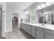 Primary bathroom with double sinks, white cabinets, tile floors, and a walk-in shower and closet at 510 Cunninghame Ct, Peachtree City, GA 30269
