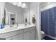 Bright bathroom featuring double sinks with a blue patterned shower curtain at 510 Cunninghame Ct, Peachtree City, GA 30269