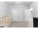 Neutral bedroom with a crib and two closets, featuring neutral paint and carpet at 510 Cunninghame Ct, Peachtree City, GA 30269