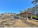 A long wooden pergola with stone supports overlooks the community pool and green space, providing a shaded seating area at 510 Cunninghame Ct, Peachtree City, GA 30269