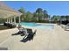 Outdoor seating area around a sparkling community pool with a covered lounge area, perfect for summer enjoyment at 510 Cunninghame Ct, Peachtree City, GA 30269