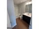 Bright and clean bathroom featuring a white tub with shower, a toilet, and dark sink and vanity at 5257 Carrie Dr, Morrow, GA 30260