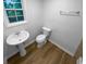 Cozy bathroom with a pedestal sink, toilet, and wood-look flooring at 355 New Marietta Hwy, Roswell, GA 30075